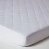 A close-up view of a white quilted mattress protector with a fitted elastic edge. Anteprima dell’immagine prodotto