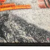 A close-up view of a textured rug or carpet with orange and gray elements. Anteprima dell’immagine prodotto
