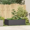 A garden scene with a planter box in the foreground, a wooden fence in the background, and various plants and trees. Náhled obrázku produktu