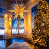 A festive Christmas scene with a decorated tree, gifts, and a large star lantern hanging in front of a window showing a snowy landscape. Anteprima dell’immagine prodotto