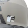 A close-up of a helmet with a sticker showing size and certification information. Náhled obrázku produktu