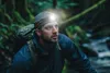 A man wearing a headlamp and backpack in a forest. Podgląd zdjęcia produktu