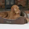 A dog lying in a dog bed in front of a fireplace. Podgląd zdjęcia produktu