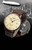 A watch is shown in front of a collage of a zeppelin and a city skyline. Produktbild-Vorschau