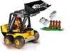 A LEGO minifigure operating a yellow front loader, dumping gray LEGO bricks near a small brown fence. Náhľad obrázku produktu