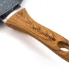 A close-up view of a frying pan handle with a wood-grain texture and a metallic rim. Náhľad obrázku produktu