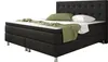 A black boxspring bed with a tufted headboard, shown with white bedding, a white pillow, and a green and white patterned throw blanket. Produktbild-Vorschau