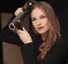 A woman is styling her hair with a hairdryer. Podgląd zdjęcia produktu