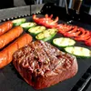 A close-up shot of a grill with steak, sausages, zucchini, and bell peppers. Produktbild-Vorschau