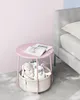 A pink side table with toys and a book next to a bed. Náhled obrázku produktu