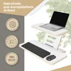 A laptop and keyboard are set up on a white standing desk converter, with green foliage in the background. Produktbild-Vorschau