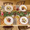 A beautifully set dining table for a festive meal, decorated with a Christmas garland and featuring plates of food. Náhled obrázku produktu