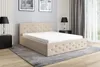 A beige upholstered bed with a mattress and a storage box, shown in a bedroom setting with nightstands and lamps.