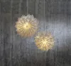 Two white paper star lanterns hang against a textured gray concrete wall. Podgląd zdjęcia produktu