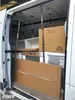 The inside of a white van filled with boxes and support poles. Produktbild-Vorschau