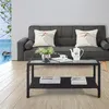A coffee table with books and a teapot is placed in front of a sofa in a living room with a view of the ocean through a window. Produktbild-Vorschau