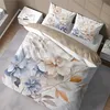 A bed with a floral duvet and pillows, next to a nightstand. Podgląd zdjęcia produktu