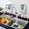 A kitchen sink with a faucet running water, a fruit basket, and a wall-mounted water purifier. Produktbild-Vorschau