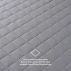 A close-up of a quilted grey fabric with diamond-shaped stitching. Produktbild-Vorschau