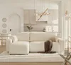 A modern living room with a sectional sofa and an open-plan kitchen in the background. Produktbild-Vorschau