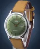 A close-up shot of an Orient automatic watch with a green dial and a brown leather strap, presented against a dark blue background. Podgląd zdjęcia produktu