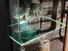 Close-up of glassware on a lit shelf in a cabinet. Produktbild-Vorschau