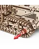 A close-up view of a wooden model of a self-propelled mower, focusing on the track and a red arrow pointing to a specific component. Podgląd zdjęcia produktu