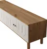 A white and wood-colored TV stand with carved door panels and wooden legs, shown from a diagonal top-down perspective against a white background. Produktbild-Vorschau