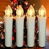Four LED candles are placed in front of a decorated Christmas tree. Produktbild-Vorschau