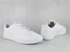 A pair of white Puma sneakers on a light gray, textured background. Produktbild-Vorschau