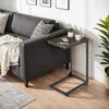 A small side table is placed next to a sofa in a living room setting. Náhled obrázku produktu