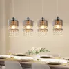A dining table set for a meal, with four crystal pendant lights hanging above. Podgląd zdjęcia produktu