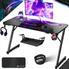 A gaming desk setup with a monitor, keyboard, mouse, headphones, and accessories, presented in a dynamic, digitally enhanced scene. Produktbild-Vorschau