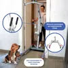 A woman is operating a patient lift in a doorway, with a dog in the foreground. Produktbild-Vorschau