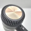 A close-up view of the top of a hairdryer, focusing on the cooling fins and the central metallic disc. Podgląd zdjęcia produktu