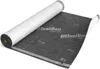 A roll of black underlayment material is partially unrolled on a white surface. Produktbild-Vorschau