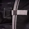 A close-up view of a strap and buckle on a black turnout blanket. Produktbild-Vorschau
