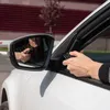 A person in a car is using a remote control to open a gate. Voir les images du produit