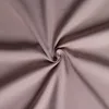 A close-up of a swirled piece of light brown and pink fabric. Produktbild-Vorschau