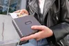 A person holding a portable photo printer and a printed photo. Produktbild-Vorschau
