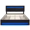 A black upholstered bed frame with blue LED lighting on the headboard and base, shown without a mattress. Náhľad obrázku produktu