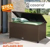 An open brown polyrattan storage box with green cushions and light blue pillows on a patio. Produktbild-Vorschau