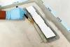 A gloved hand is using a brush to apply a substance to a surface, with a tool resting on the surface. Produktbild-Vorschau