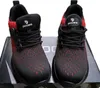 A pair of black and red safety shoes are displayed on a box. Produktbild-Vorschau