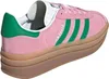 A close-up studio shot of a pink Adidas Gazelle sneaker with green stripes and a thick brown sole. Produktbild-Vorschau