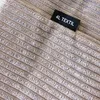 A close-up view of a textured fabric with a label. Produktbild-Vorschau