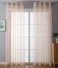 A window covered by sheer curtains, with a small framed picture on the left and a wooden dresser on the right. Produktbild-Vorschau