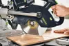 A person is using a miter saw to cut a piece of wood. Podgląd zdjęcia produktu