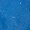 A close-up view of a blue tarp with a textured surface and small reflective threads. Produktbild-Vorschau