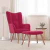 A magenta velvet armchair and ottoman are placed on a rug in a room with sheer curtains in the background.